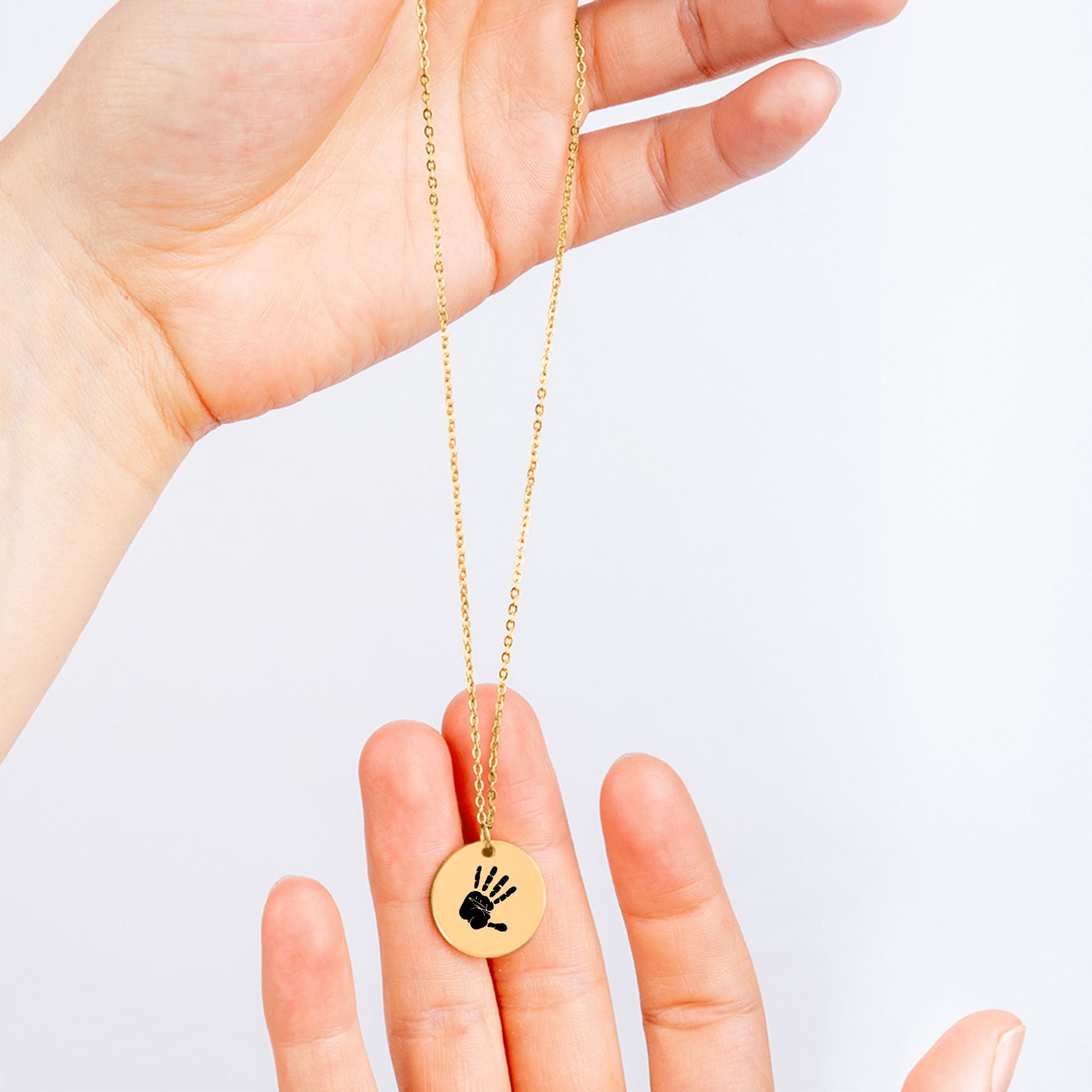 Vergoldete Halskette mit rundem Anhänger und eingraviertem Handabdruck, personalisierter Schmuck als emotionale Geschenkidee