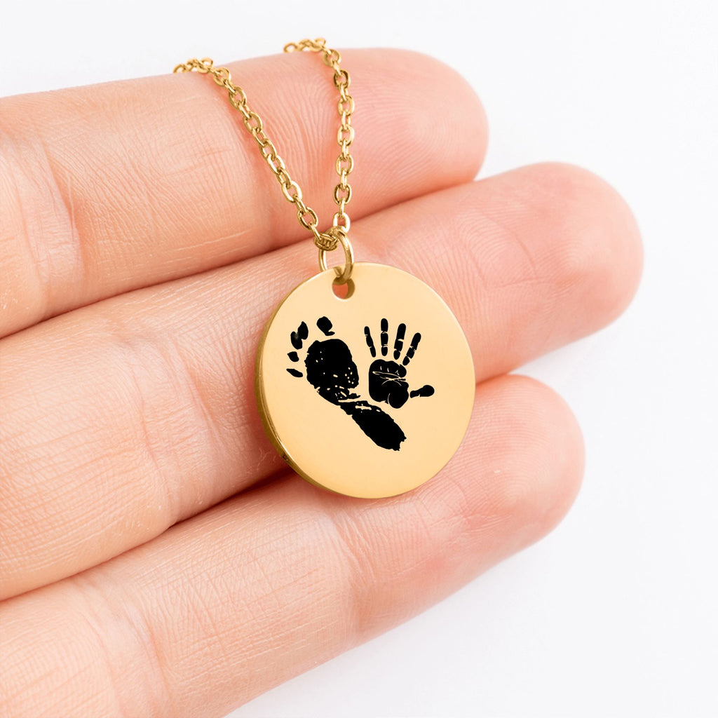 Personalisierter vergoldeter Anhänger an einer Kette mit kombinierter Gravur eines Baby-Handabdrucks und eines Fußabdrucks in Schwarz