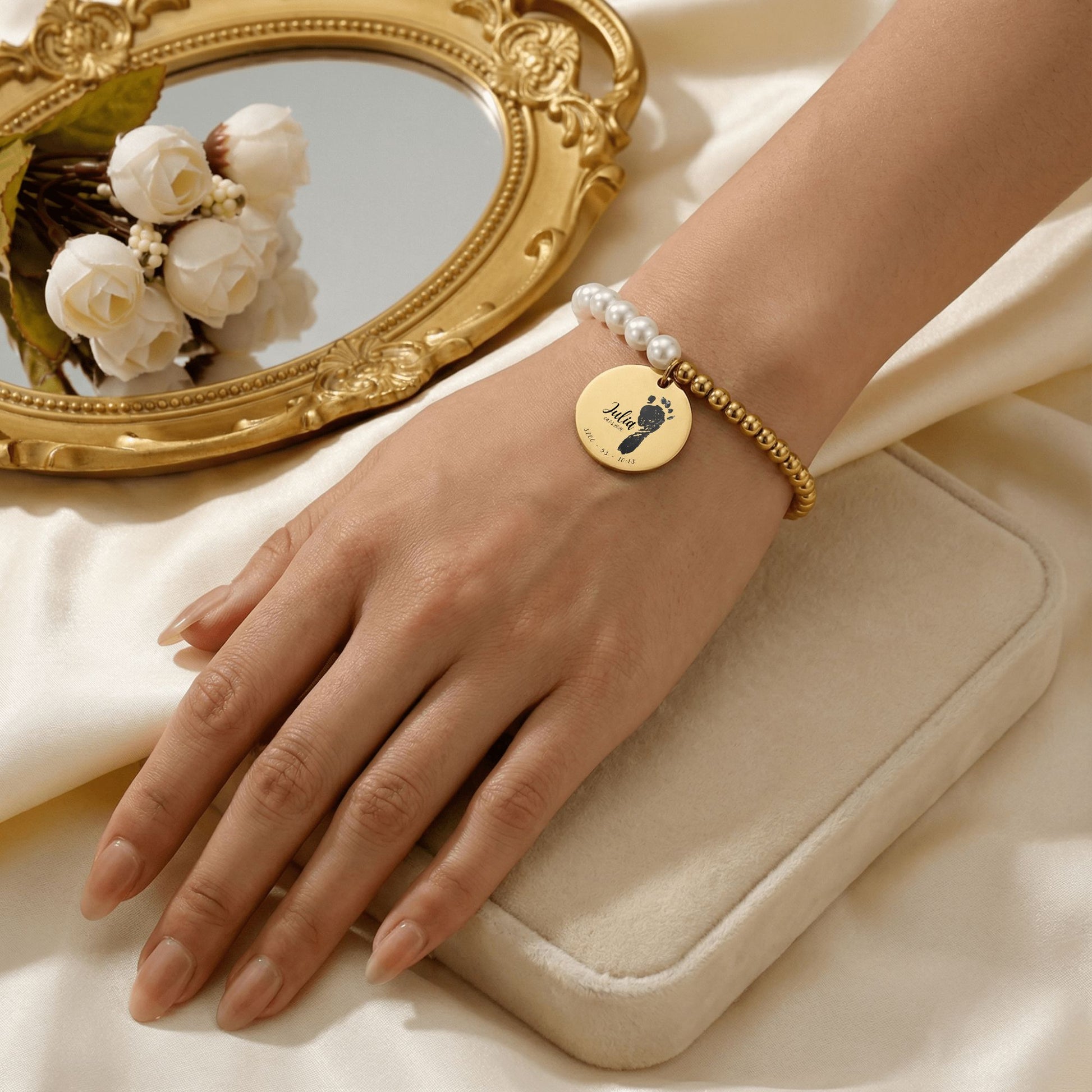 Lifestyle-Foto einer Hand, die eine personalisierte Armband  mit Fußabdrücken, Namen, Geburtsdatum, Körpergröße, geburtuhrzeit trägt
