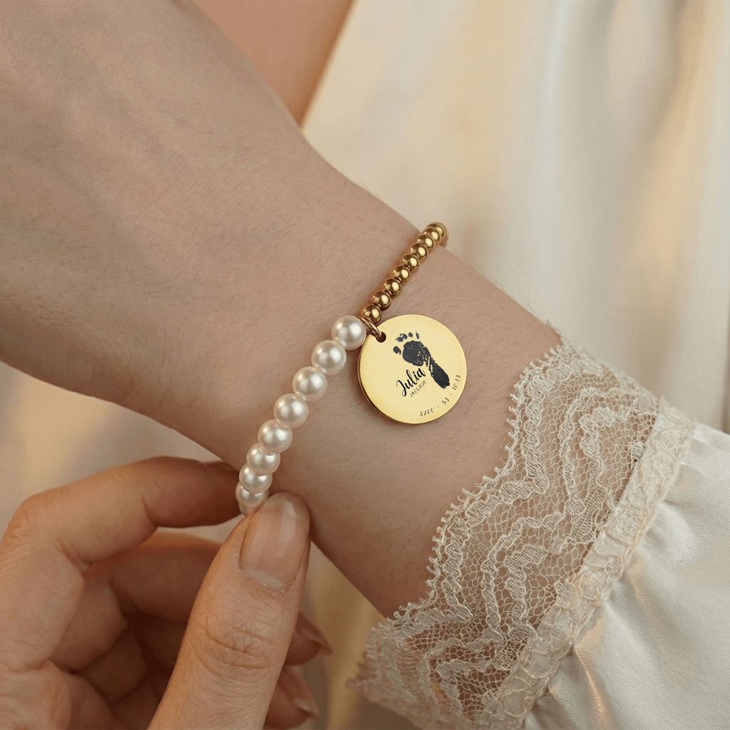 Perlenarmband am Arm getragen, Nahaufnahme mit Händen und sichtbarer Armband mit name,körpergröße,geburtsdatum,geburtsuhrzeit nah aufnahme