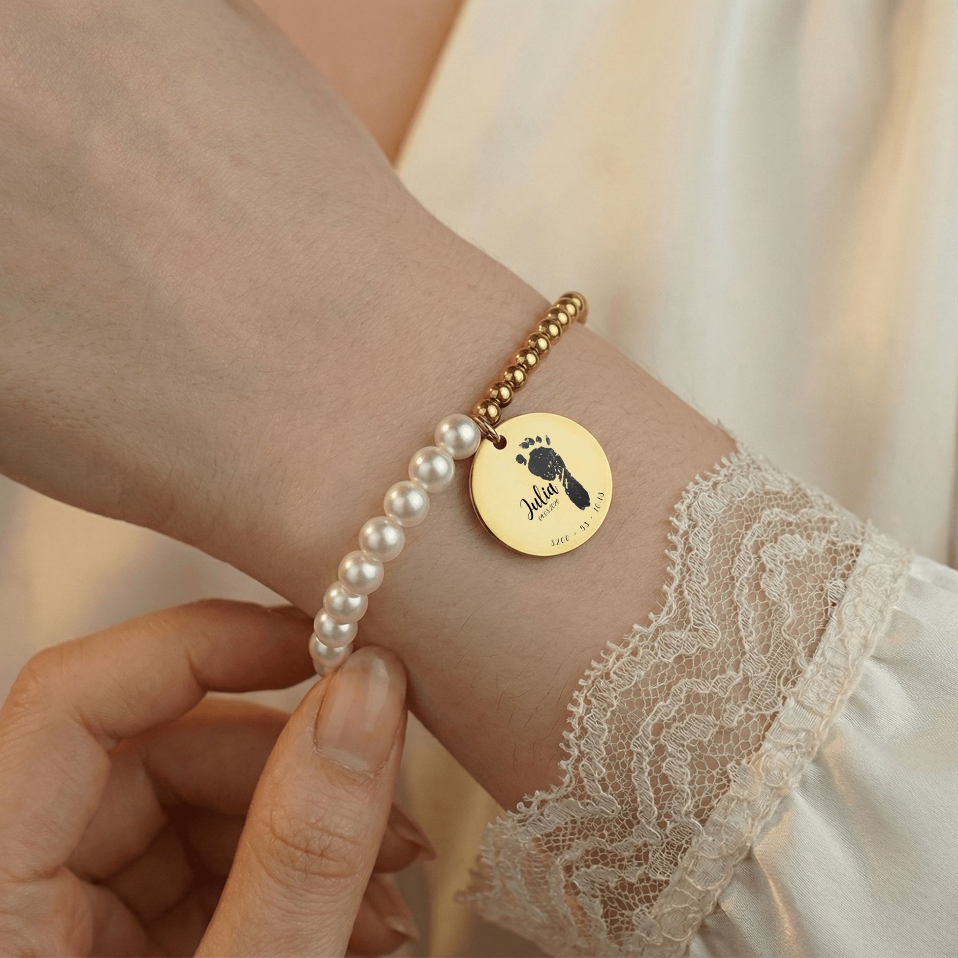 Perlenarmband am Arm getragen, Nahaufnahme mit Händen und sichtbarer Armband mit name,körpergröße,geburtsdatum,geburtsuhrzeit nah aufnahme